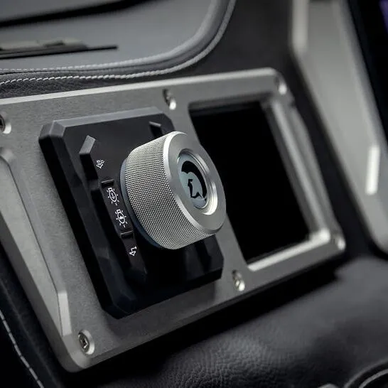 Close-up of a metallic rotary knob with icons for lights and windshield functions on the Nv Series dashboard, designed to Make The Features Personal with customizable controls.