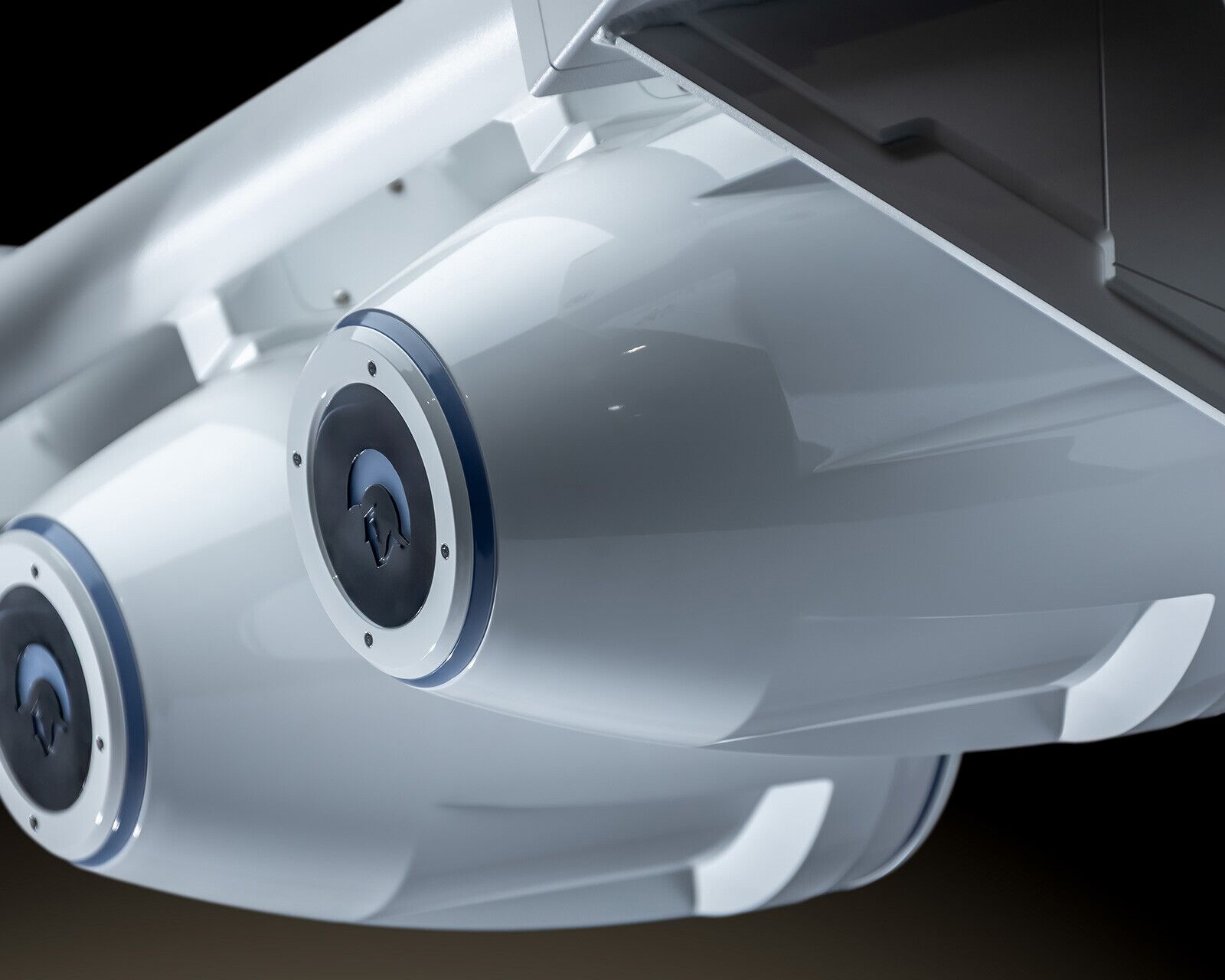 Close-up view of two white cylindrical pods attached under an aircraft wing, featuring circular hatches and a sleek, modern design reminiscent of the streamlined aesthetics found on a Centurion Nv213.