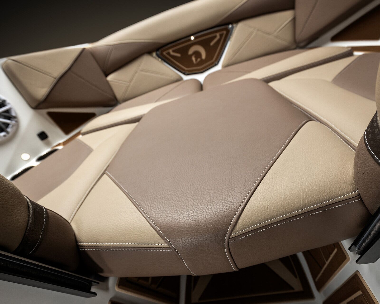 Close-up view of beige and brown leather seats with visible stitching in the Centurion Nv213, accompanied by a speaker and geometric panel design in the background.