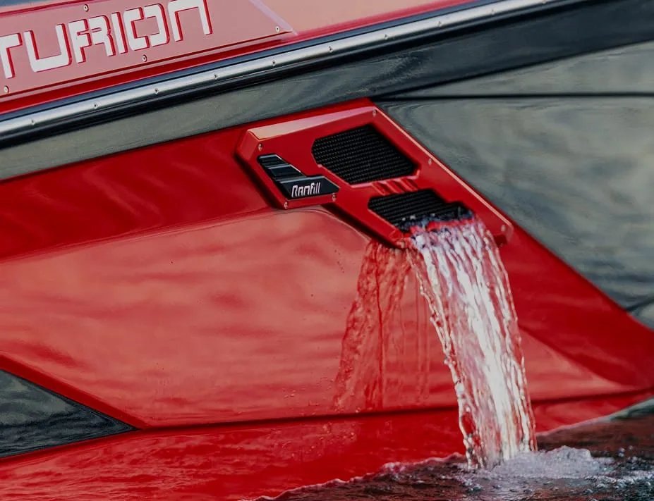 Close-up of a red boat hull with water flowing out of a Centurion RAMFILL vent labeled