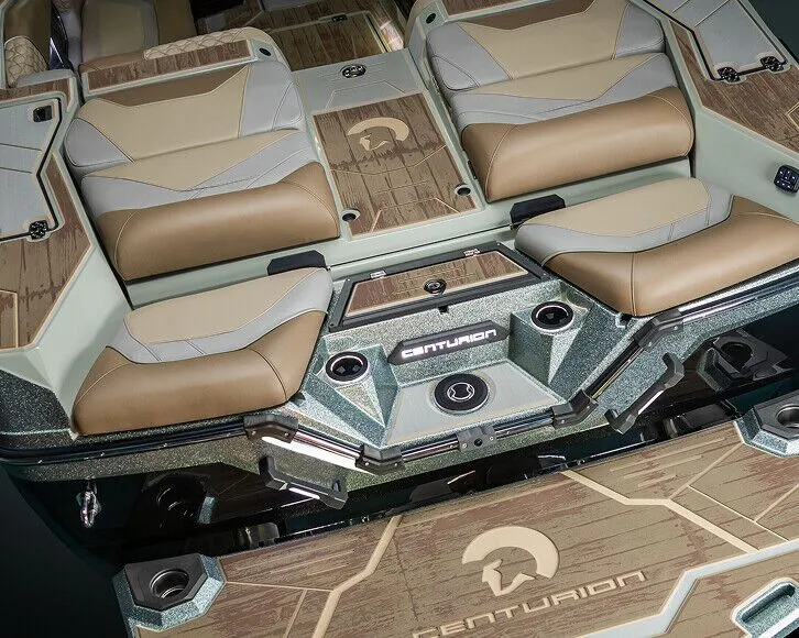 Close-up view of the rear seating and swim platform area on a Centurion Nv Series Surf Boat, featuring tan and gray upholstery and branded decking.