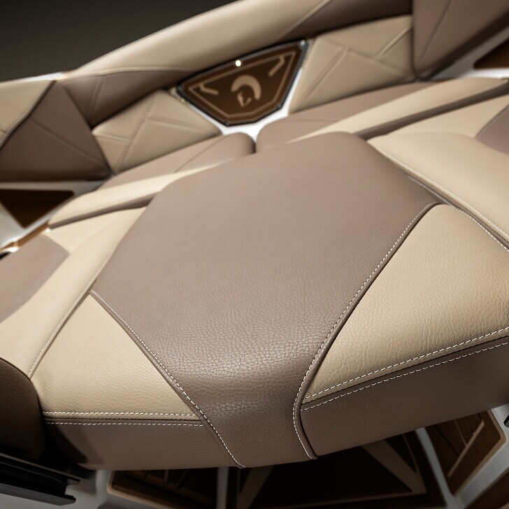 Close-up view of a modern boat seat with beige and brown leather upholstery and geometric stitching patterns.