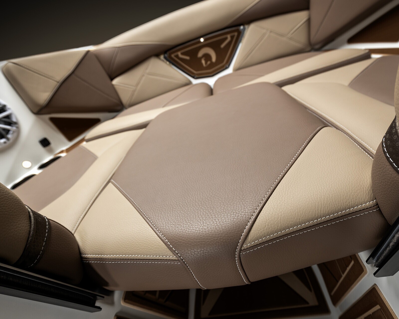 Close-up view of beige and brown leather seats with visible stitching in the Centurion Nv213, accompanied by a speaker and geometric panel design in the background.