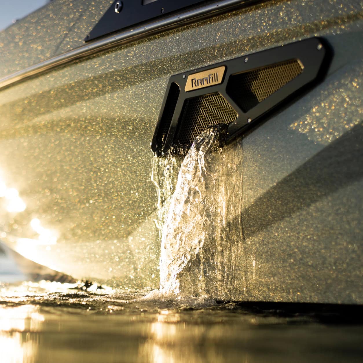 Close-up of water flowing out of a metallic vent labeled 