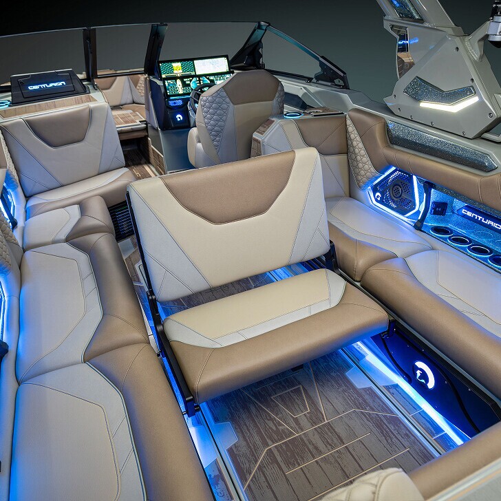 Luxury boat interior with tan and beige leather seats, blue LED lighting, multiple cup holders, and digital control panels.