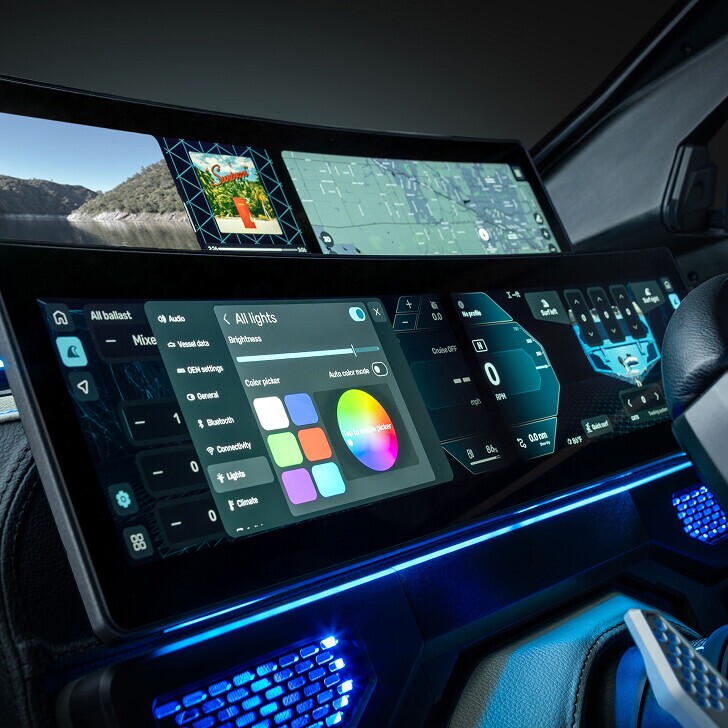 Wide digital dashboard displays navigation, controls, and a color picker for lighting in a high-tech vehicle interior, with blue accent lighting and a partial view of the steering wheel.