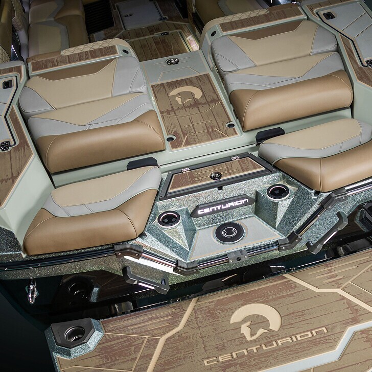 The interior of a Centurion boat shows cushioned seating, cup holders, and branded flooring with a Centurion logo.