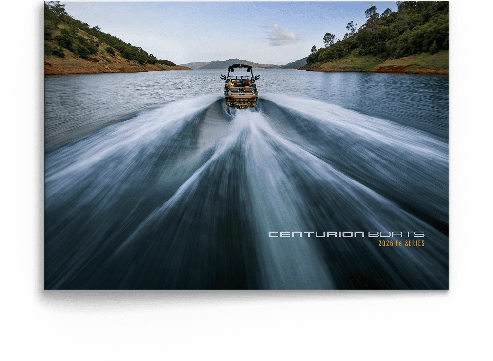 A speedboat moves quickly across a wide lake, leaving a trail of wake behind it. Hills with trees line both sides of the water. The text reads, 