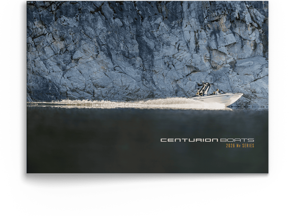 A white speedboat travels quickly across a calm body of water near a steep rocky cliff, with 