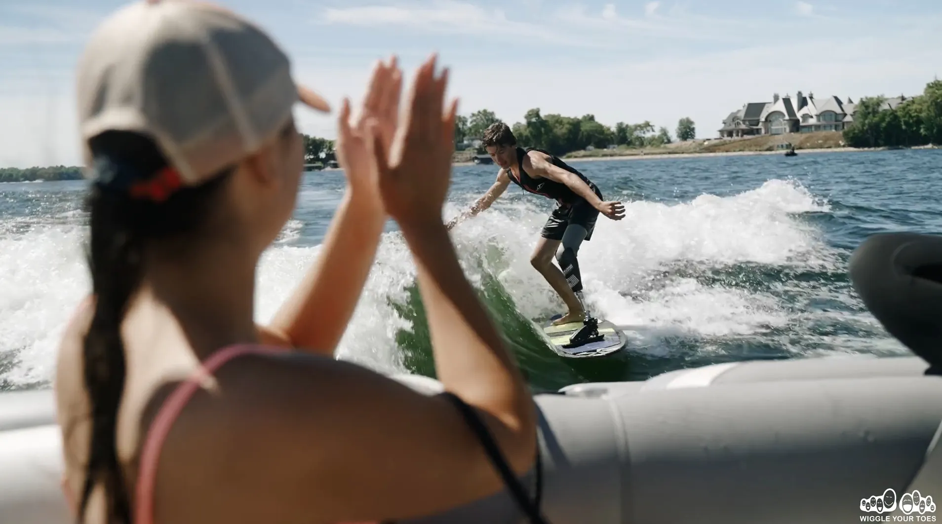 A woman is riding a wakeboard on a boat.