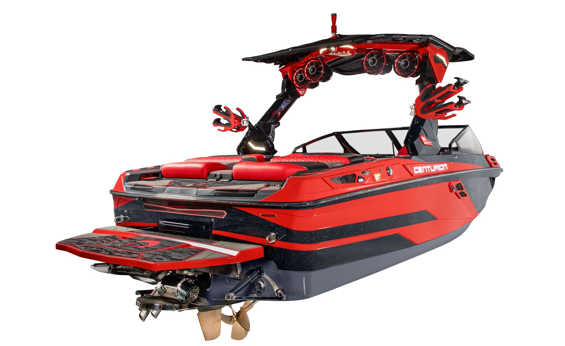 A red and black Centurion Ri230 Surf Boat with tower-mounted speakers and board racks, viewed from the rear side angle against a white background.