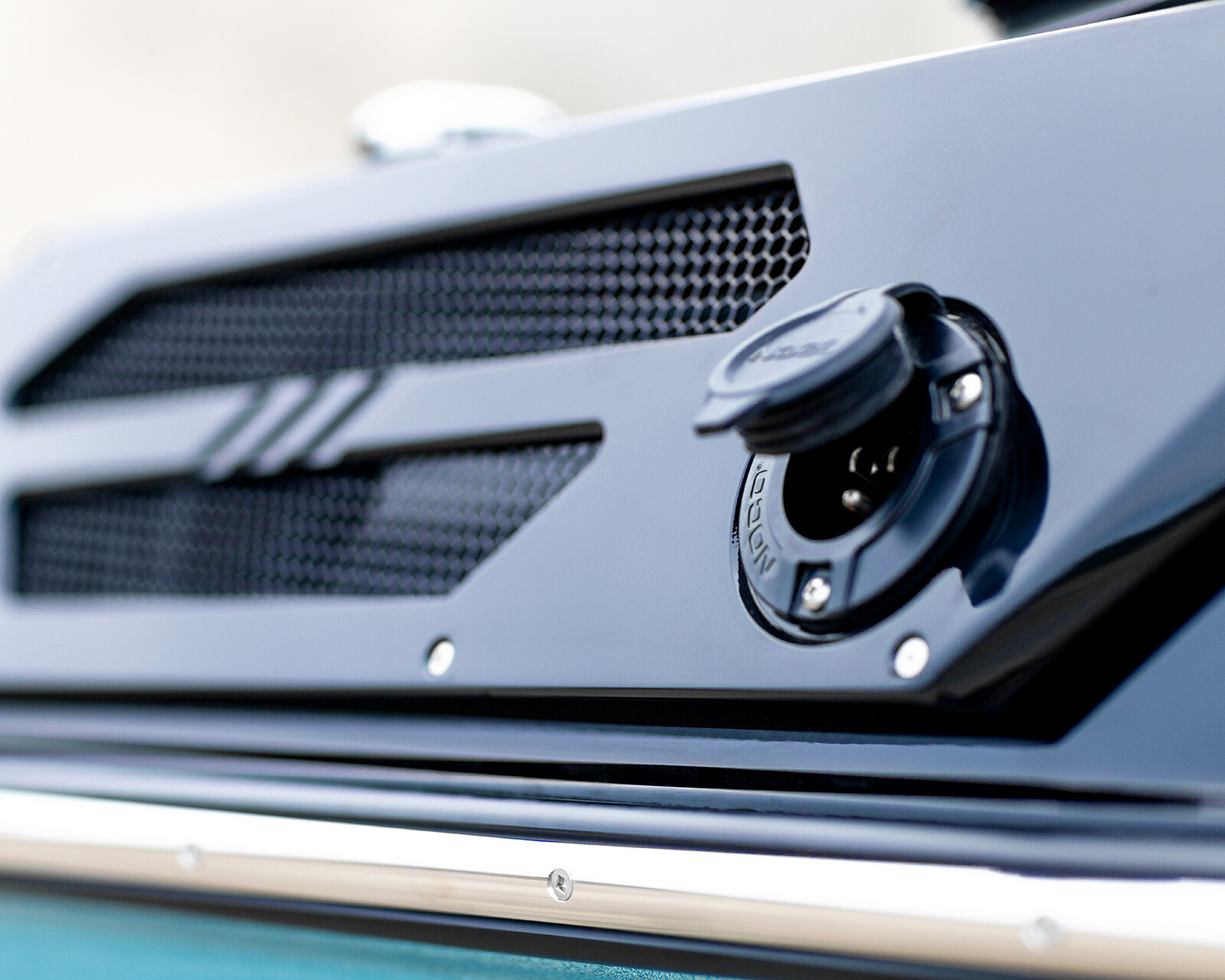 Close-up of a black fuel cap and vent grille on the glossy panel of a Centurion Ri245 Surf Boat.
