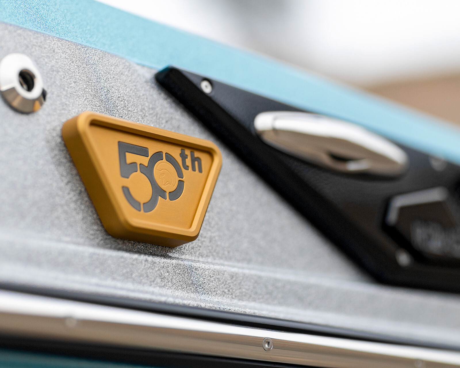 Close-up of a metallic surface with a gold badge displaying 