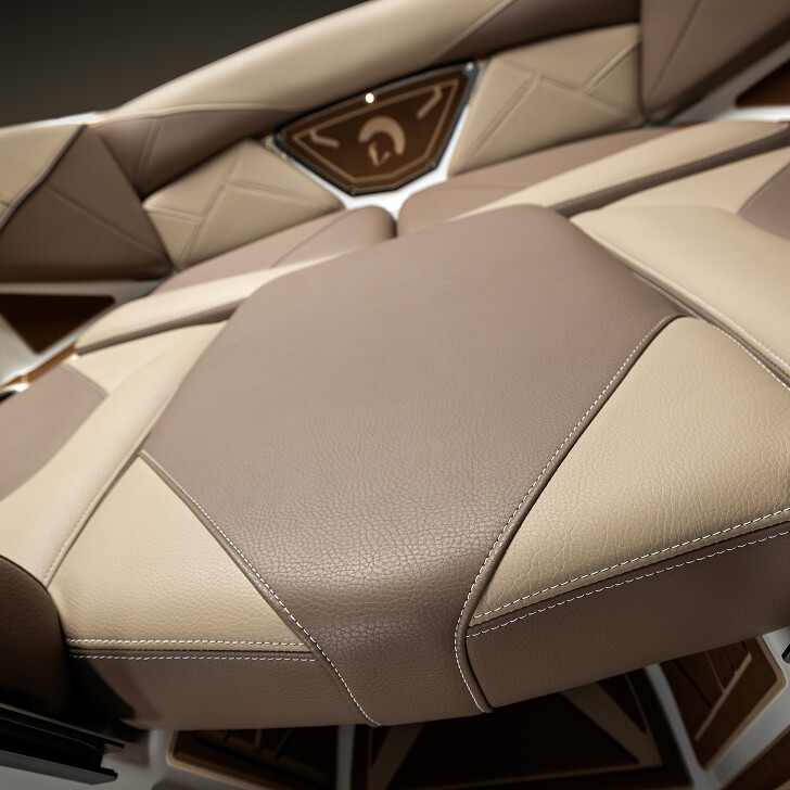 Close-up view of a modern boat seat with beige and brown leather upholstery and geometric stitching patterns.