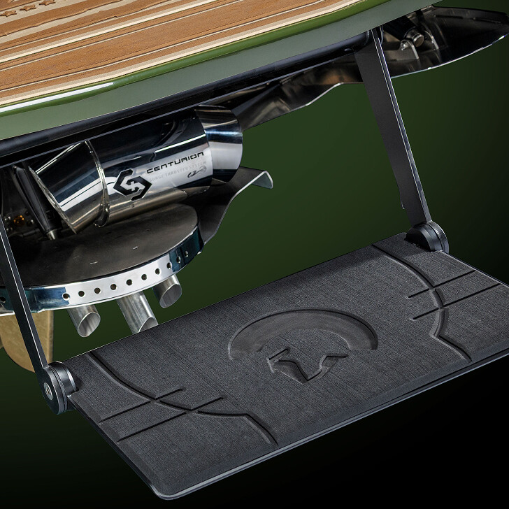 Close-up view of a boat's onboard mechanical components, including a Centurion exhaust system and a textured platform with a Spartan helmet logo.