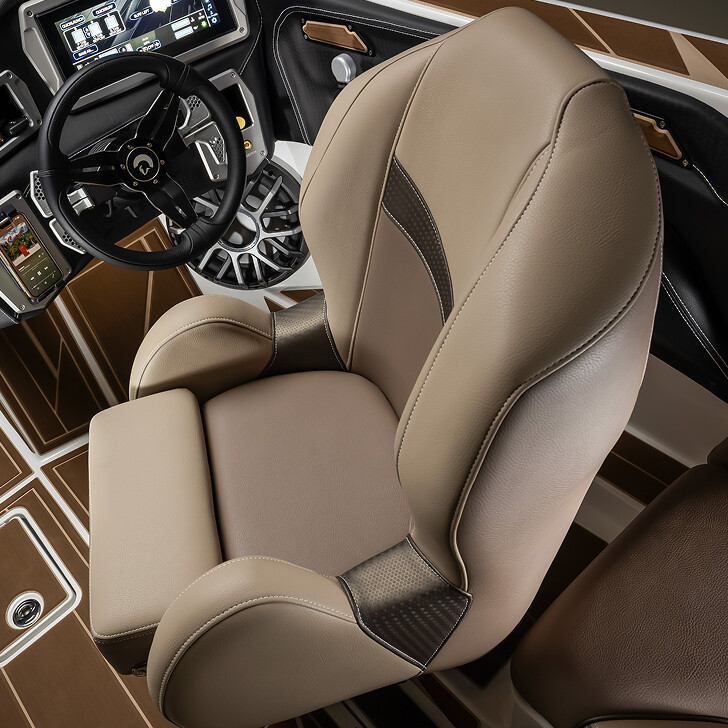 Close-up view of a modern boat cockpit featuring a leather captain's chair, a steering wheel, and dashboard controls with brown and beige interior accents.