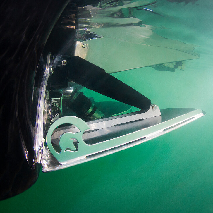 Close-up view of an underwater hydrofoil attached to a boat, with clear water and mechanical details visible.