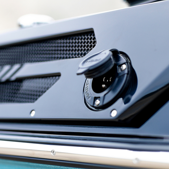 Close-up view of an electric charging port on a dark-colored Ri Series vehicle, with the port cover flipped open—showcasing Features Personal convenience and advanced electric innovation.