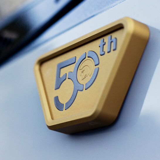A gold and silver emblem on an Nv Series vehicle reads 