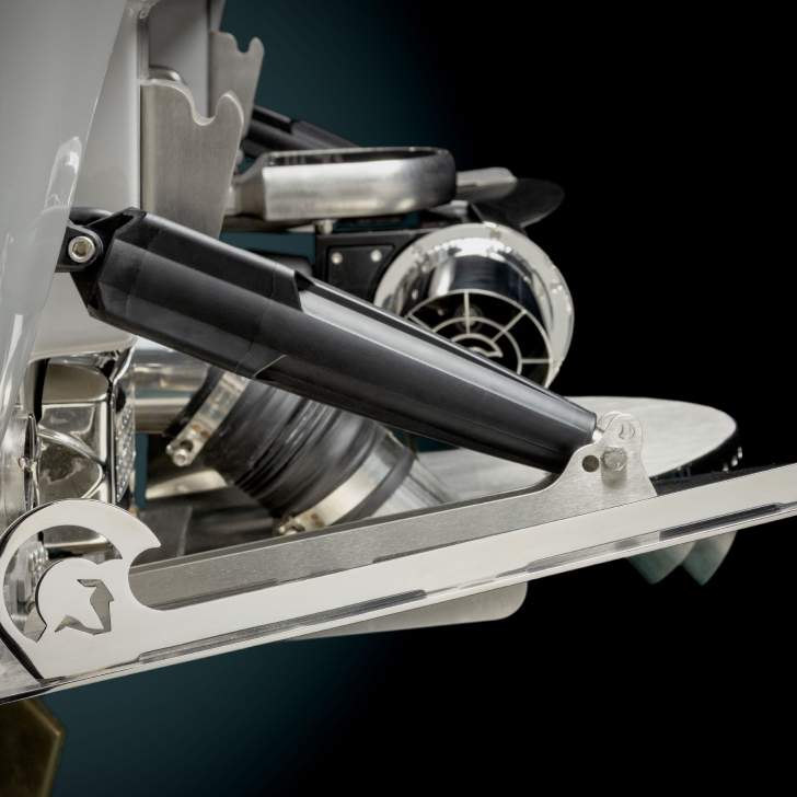 Close-up of a metallic mechanical component from the Nv Series, featuring a hydraulic piston, gears, and a star-shaped cutout, set against a black background.