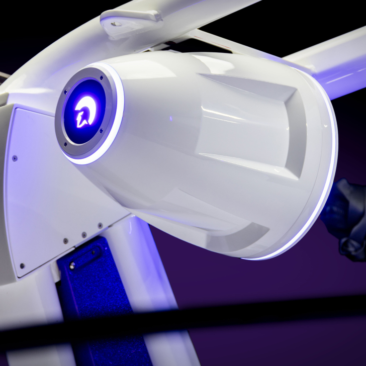 Close-up of a white robotic arm from the Nv Series with blue and purple lighting, featuring a circular illuminated element on the side. Features Personal integration for enhanced interaction.