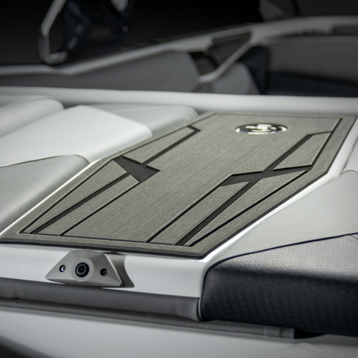 Close-up of a modern Nv Series boat interior featuring padded white and grey seating with a textured, geometric-patterned deck panel and features personal comfort touches throughout.