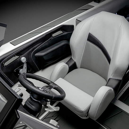 A modern Nv Series vehicle cockpit featuring a single light-gray seat, black steering wheel, gear lever, and door panel with metallic and carbon fiber finishes. Features Personal comfort and advanced functionality throughout.