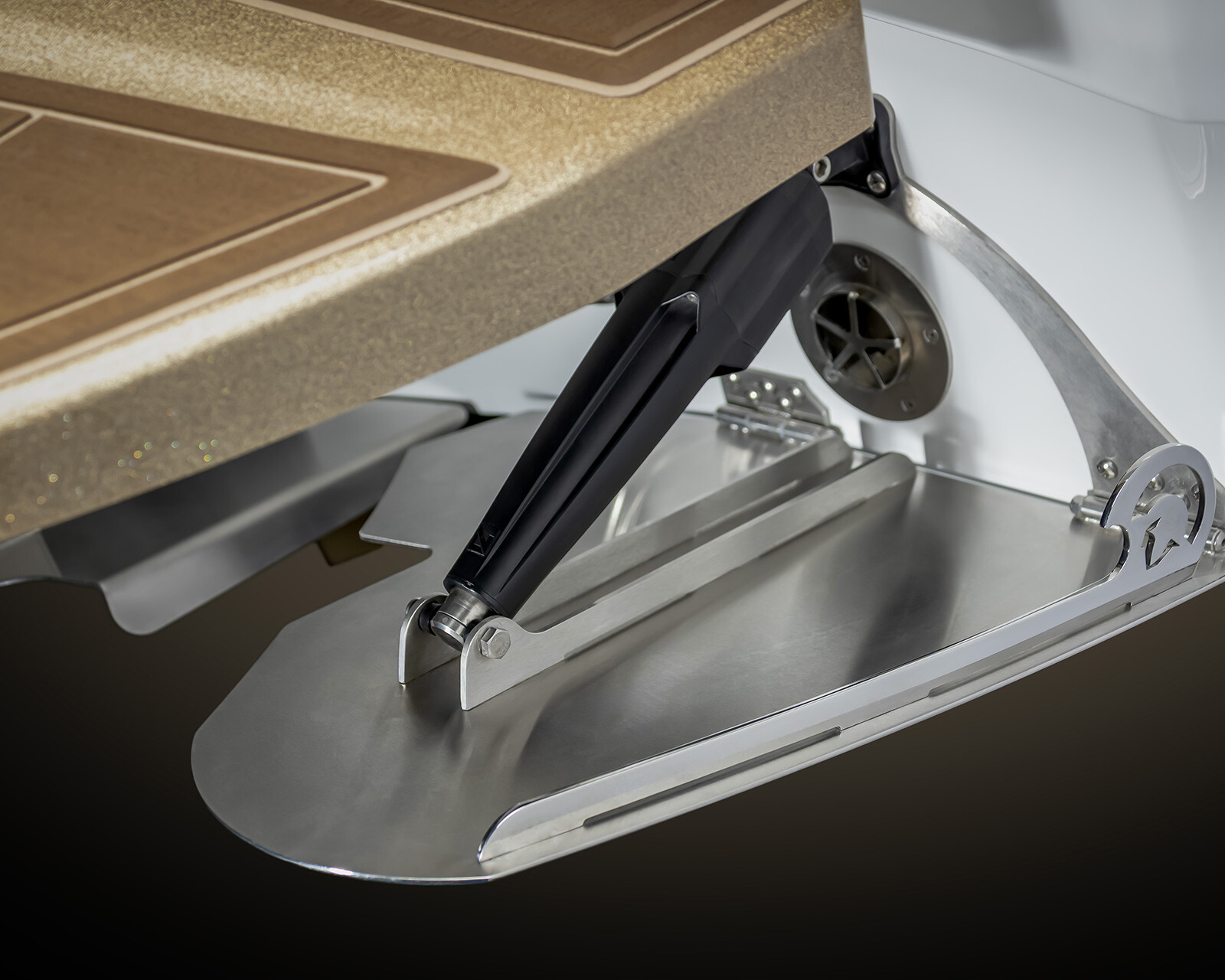 Close-up view of a metal trim tab with hydraulic actuator mounted beneath a Centurion Nv213 Surf Boat’s swim platform.