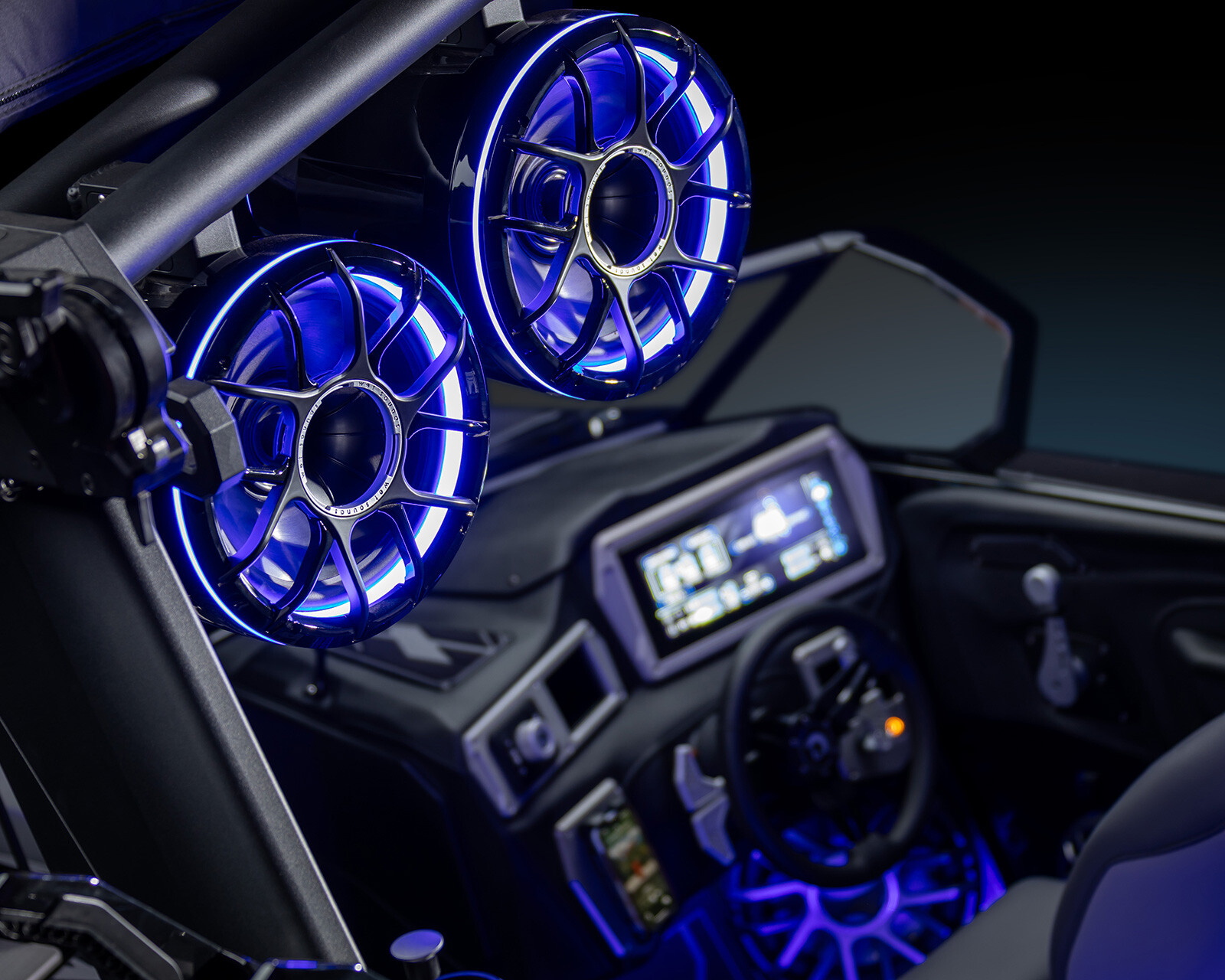 Close-up of a Centurion Nv233 interior featuring two illuminated blue speakers mounted above a dashboard with digital displays and controls.