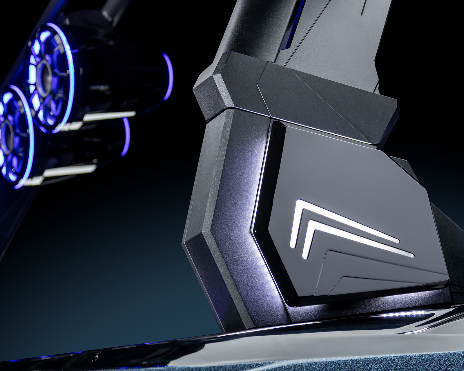 Close-up of a futuristic, illuminated control panel with geometric shapes and glowing blue accents, featuring the Centurion Nv233 Wake Boat’s double chevron logo.