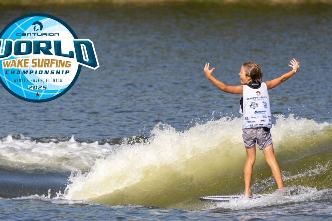 A young surfer rides a wake on a lake, arms raised, wearing a competition jersey. The Centurion World Wake Surfing Championship 2025 logo is displayed on the left.