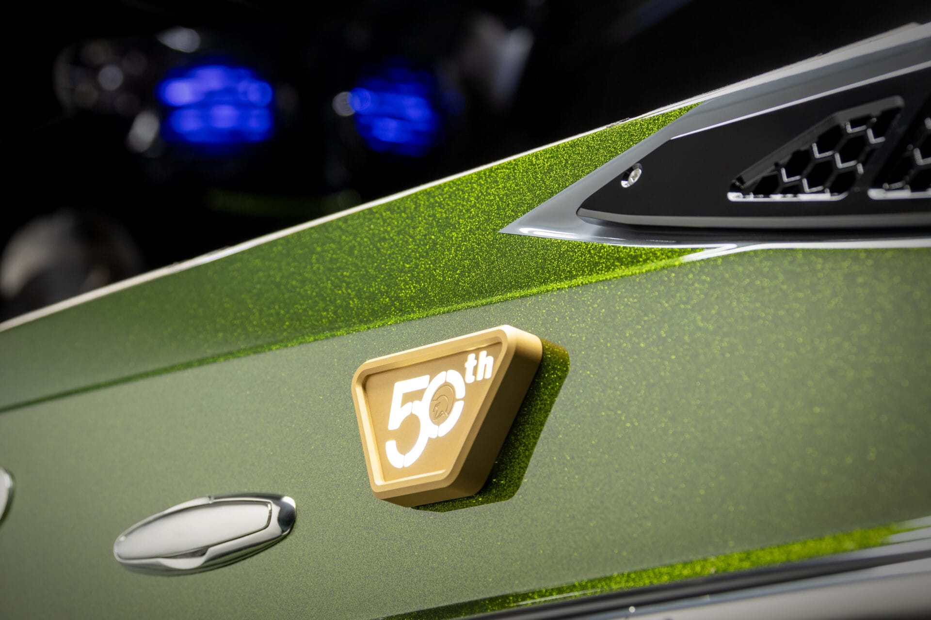 Close-up of a green metallic car with a gold 
