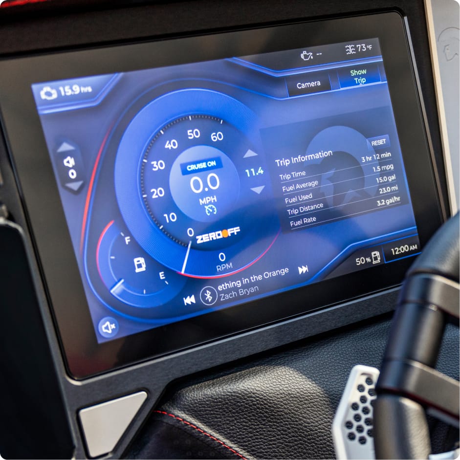 Close-up of a vehicle’s digital dashboard display showing speed, cruise control, trip info, fuel level, and media playback with a Zach Bryan song—much like tracking Centurion Boat Fuel Efficiency at a glance.