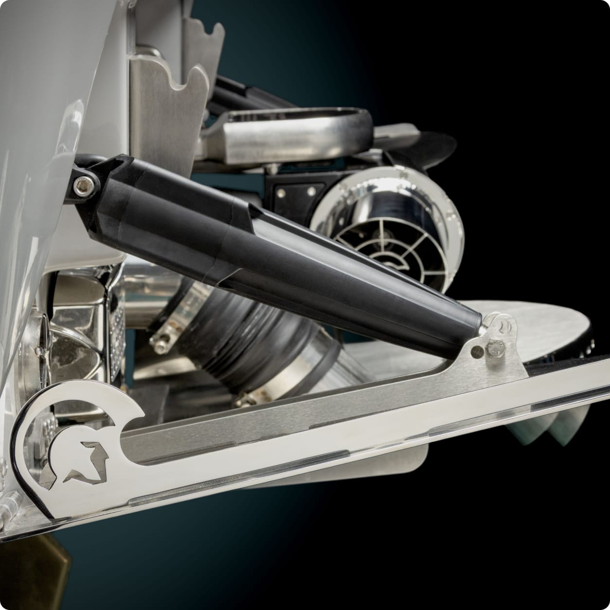 Close-up of a metal component with a black lever, circular elements, and cut-out star design—part of a complex Centurion surf wave mechanical device set against a black background.