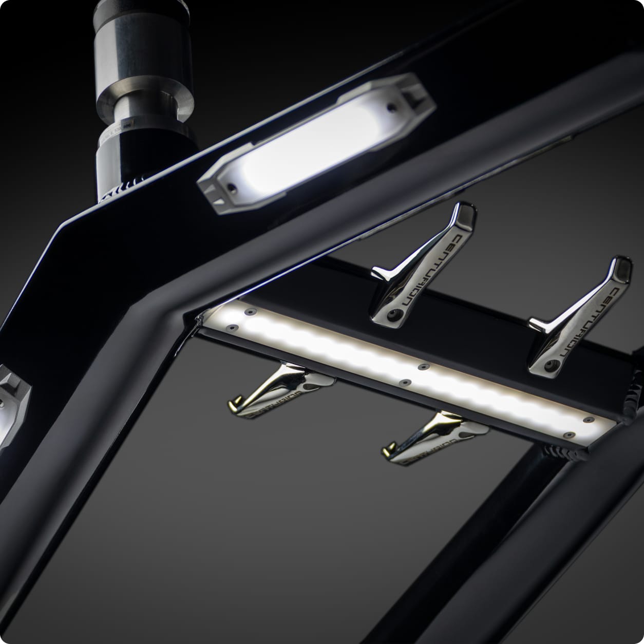 Close-up view of a metallic frame with built-in LED lights and three spring clamps attached underneath, set against a dark background—echoing the modern design of Centurion Towers.