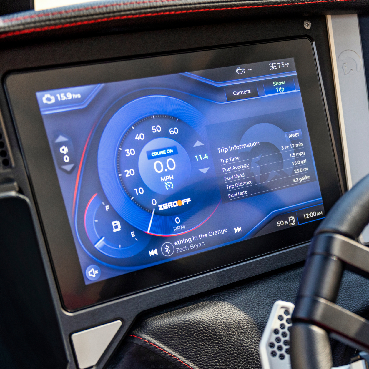 A car dashboard display shows digital speedometer, fuel economy, trip information, and music track details, along with time and temperature indicators.