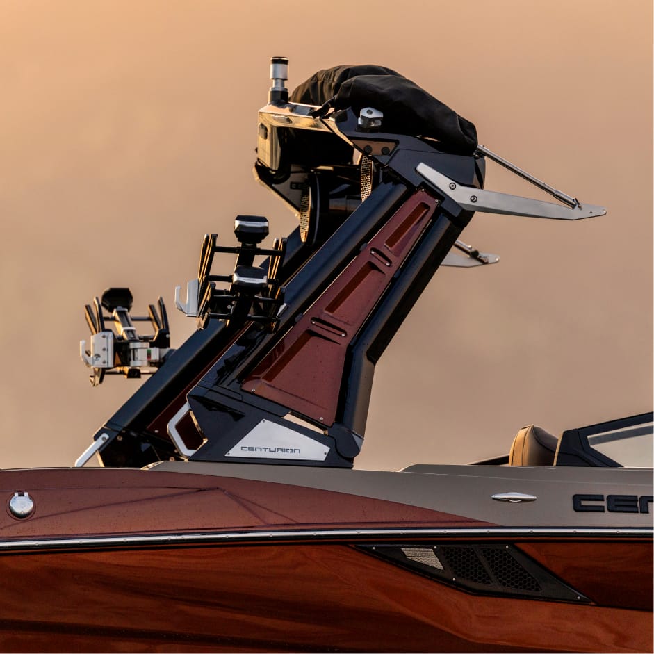 Close-up side view of a maroon Centurion boat featuring a metallic wakeboard tower with racks and mounted equipment, highlighting the innovative Opti-V Hull design against a neutral background.
