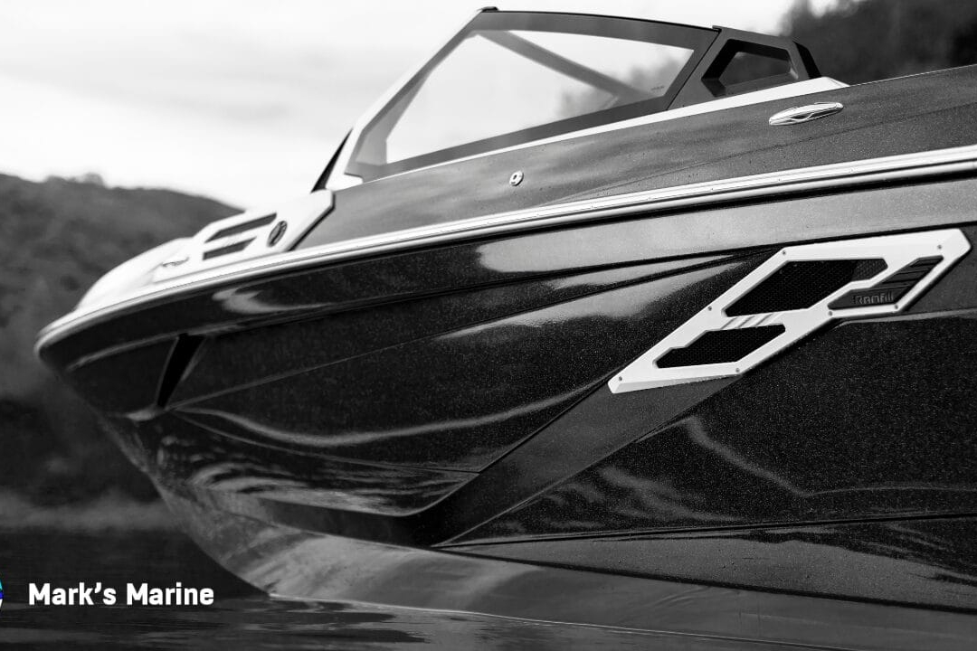 Close-up, side view of a sleek, modern speedboat on the water; hills in the background; Mark’s Marine logo and name in the lower left corner.