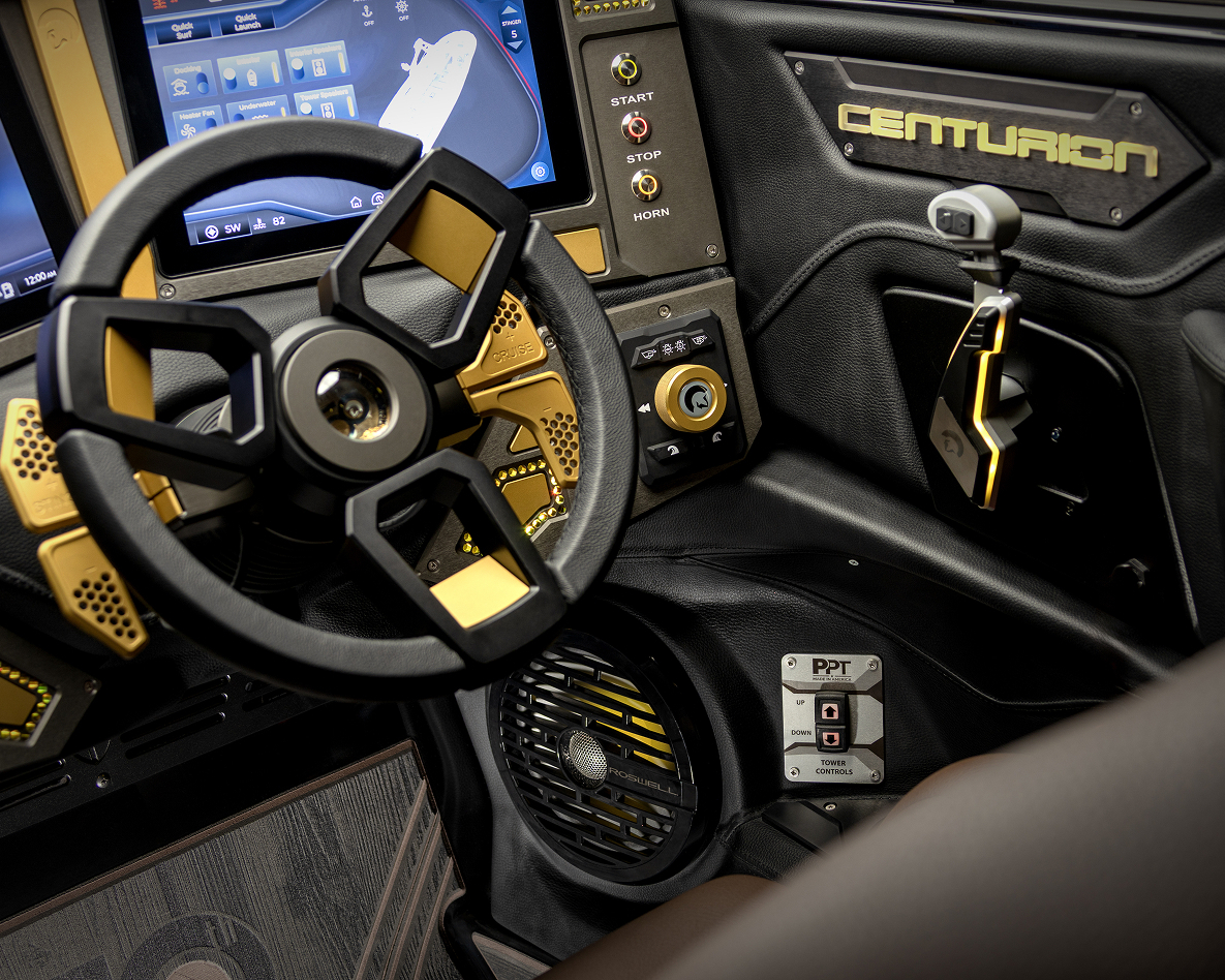 Close-up of a high-tech Centurion Ri230 cockpit featuring a modern steering wheel, joystick control, display screens, labeled buttons, and a Centurion nameplate.