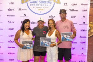 Four people pose and smile while holding certificates in front of a branded backdrop at the 2026 Wake Surfing Championship in Winter Haven, Florida.
